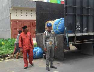 Kasi Ops Satpol PP Rohil, Syafei menertibkan truk barang yang parkir di badan jalan. <b>FOTO: Afrizal</b> 